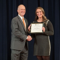 Doctor Potteiger posing for a photo with an award recipient in a grey dress